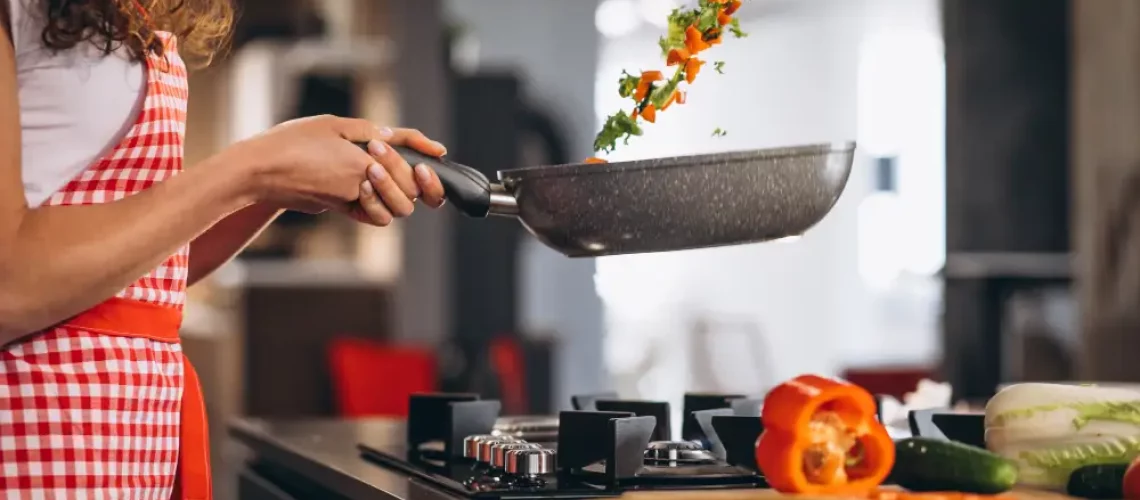 woman-chef-cooking-vegetables-pan
